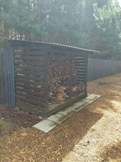 Obrazek przedstawia własnoręcznie wykonane, drewniane pomieszczenie do przechowywania drewna